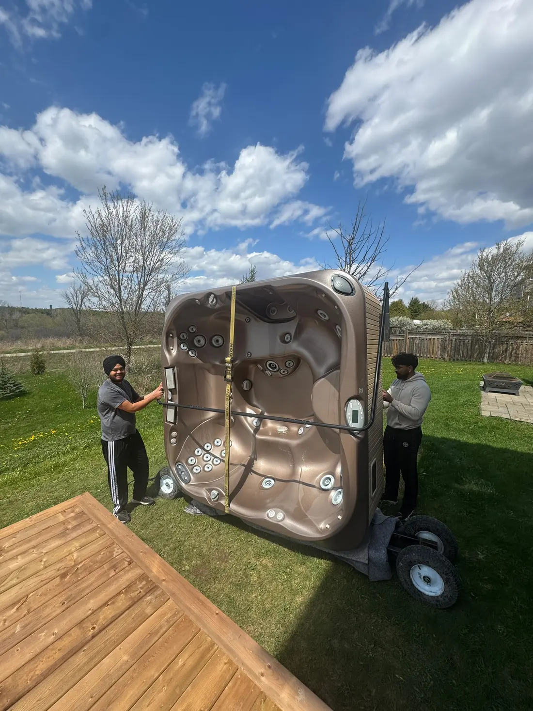 EC Movers crew moving a hot tub past a deck