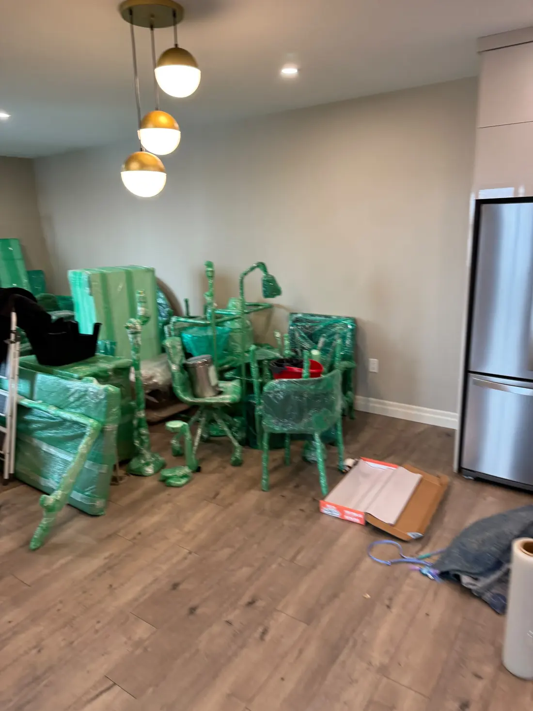 Wrapped furniture staged in the corner of a room for a move