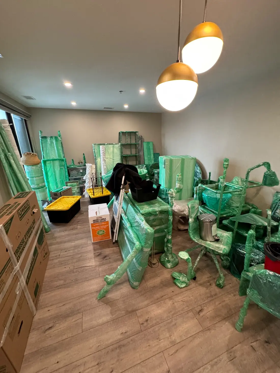 Furniture and boxes wrapped and staged in a room by EC Movers before loading