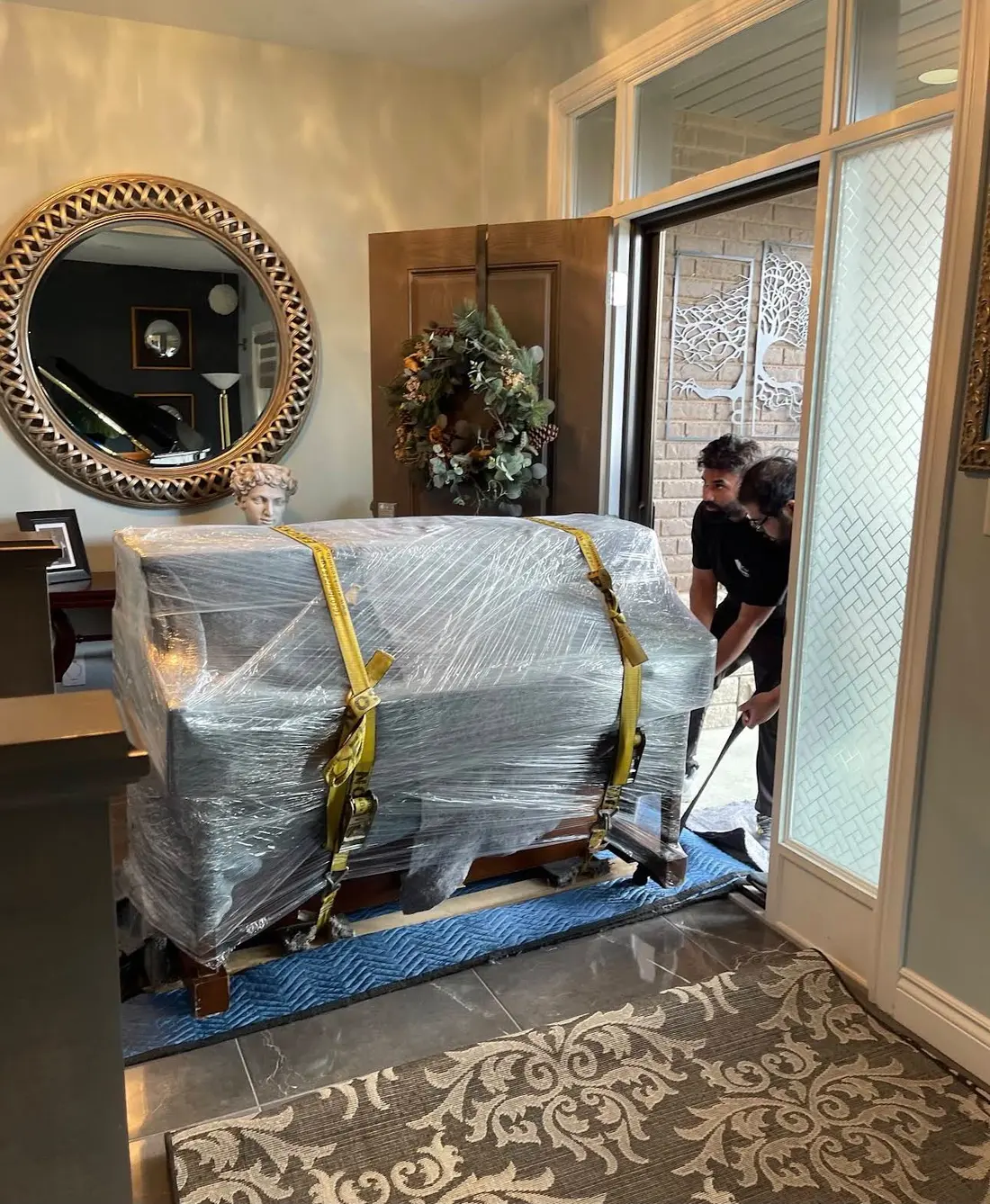 Grand piano wrapped and strapped on a skid board by EC Movers