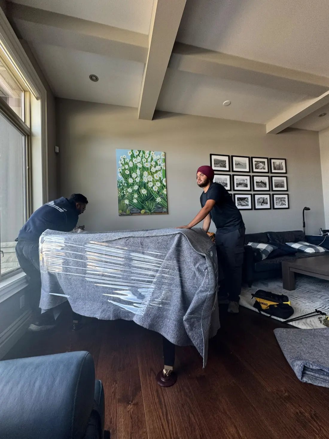 EC Movers crew wrapping a grand piano in moving pads