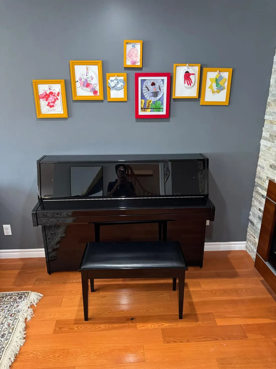 Black upright piano with its bench in a living room before an EC Movers move