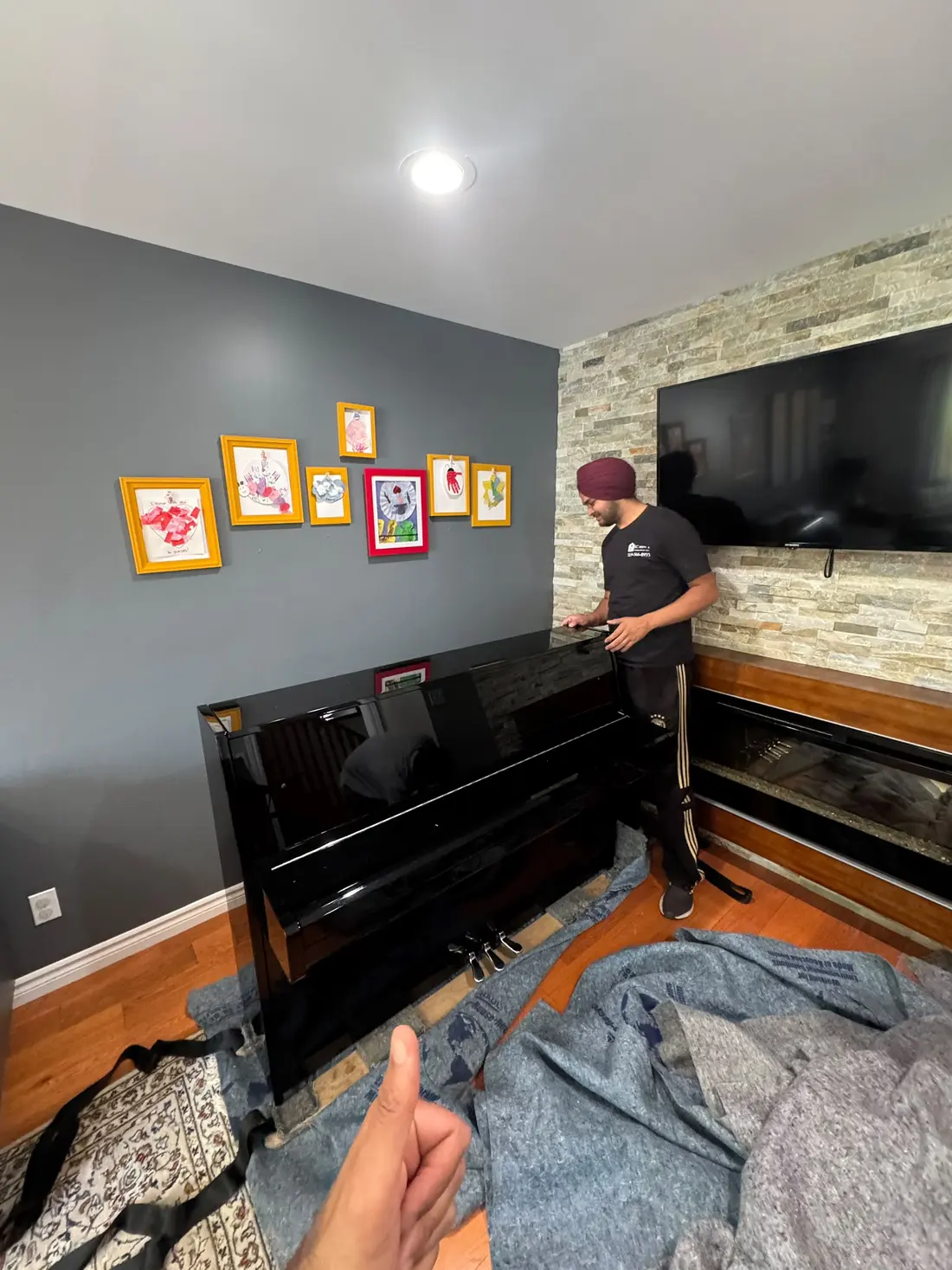 Upright piano with moving blankets on the floor