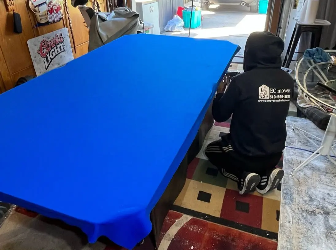EC Movers crew member finishing new felt on a pool table