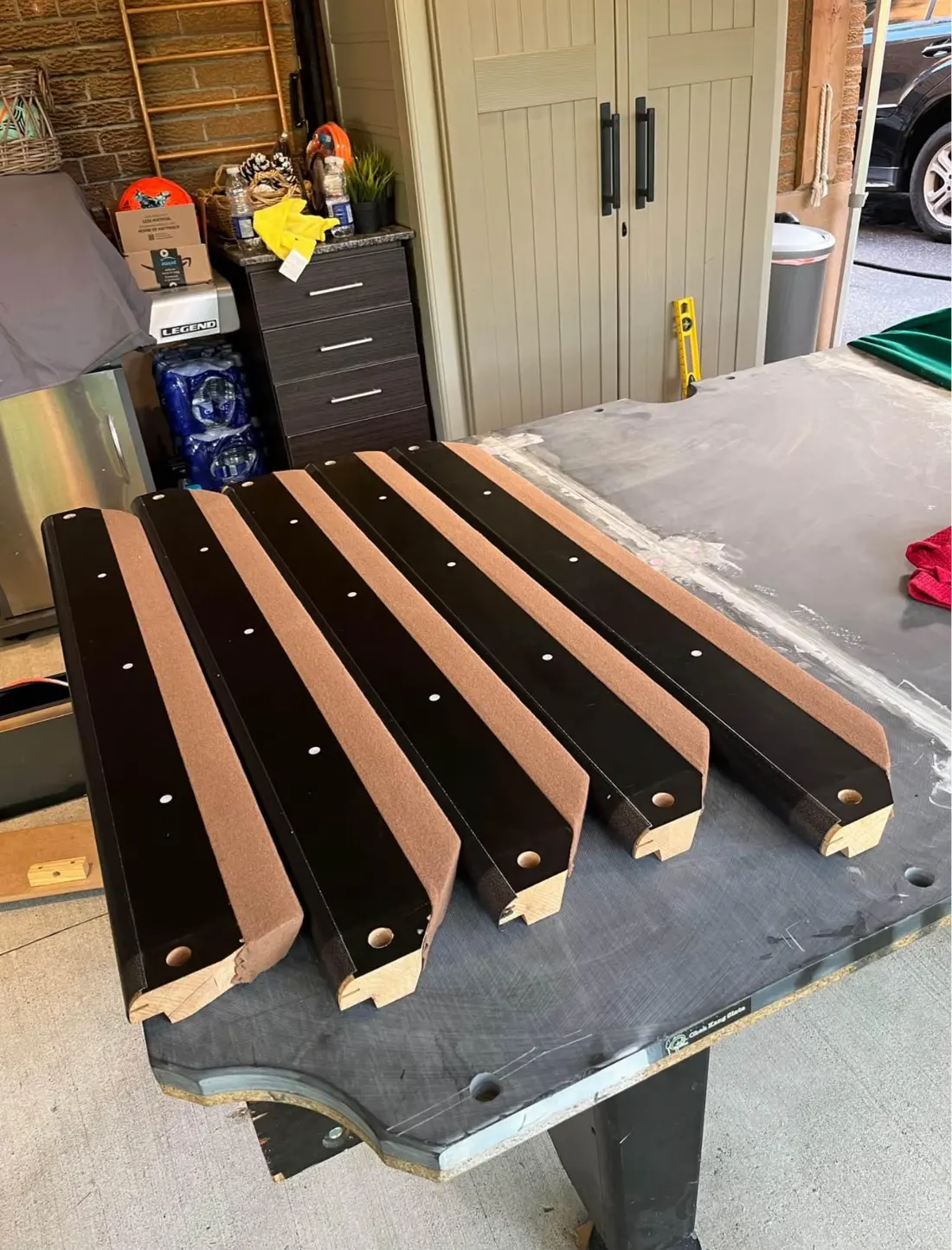 Pool table rails with new tan cloth ready to be refitted