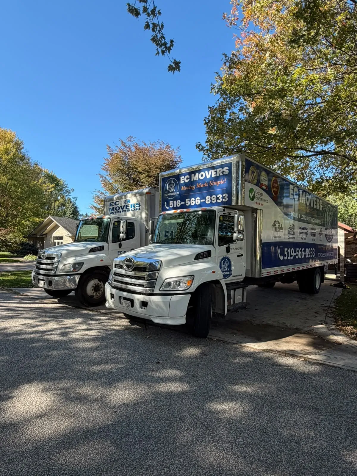 Two EC Movers moving trucks parked in a Windsor driveway